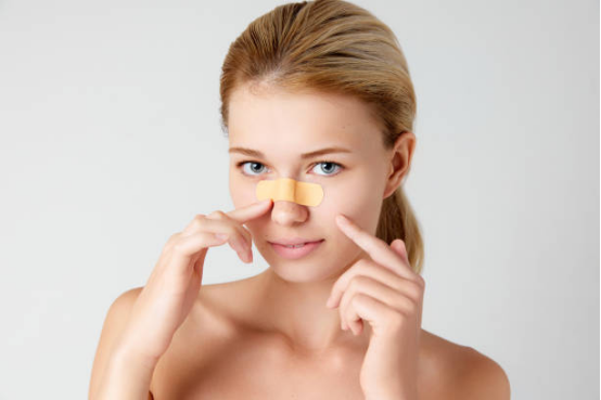 Person using nasal strips for long-term relief from chronic nasal congestion.
