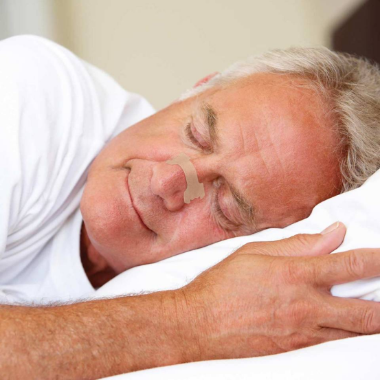 Person sleeping peacefully after using nasal strips to clear nasal passages.