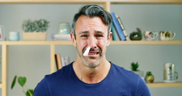 Man with runny nose, considering nasal strips for better breathing.