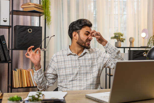 Man pinching his nose, needing nasal strips for clear breathing.