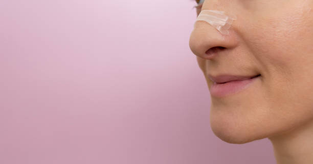 Woman's profile with a clear nasal strips for improved breathing.