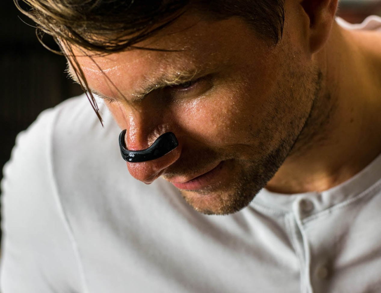 Man wearing a black innovative nasal strip for comfortable breathing relief.