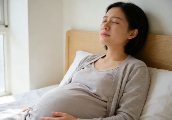 Pregnant woman sleeping peacefully in bed, benefiting from nasal strips for rest.