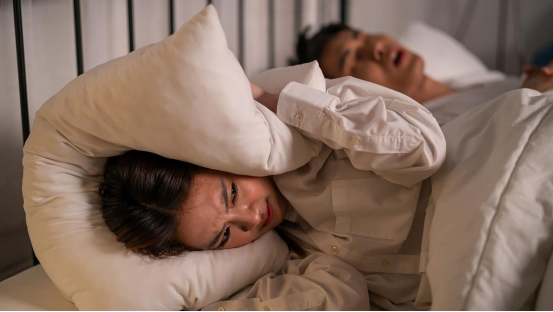 Person wearing nasal strips at night to reduce morning fatigue.